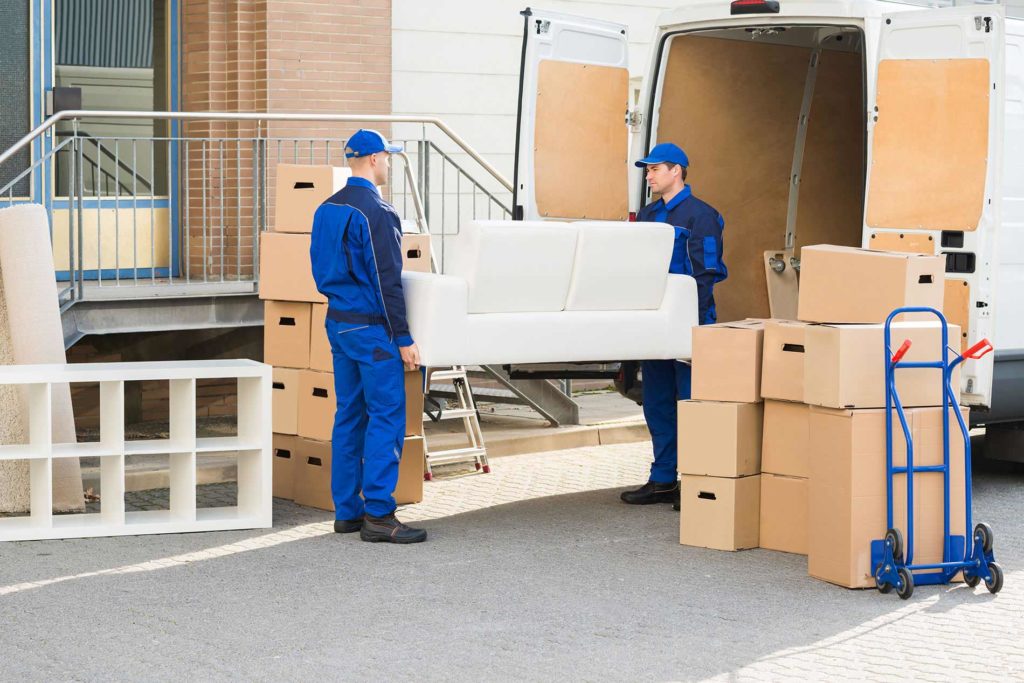 Two men unloading furniture from a moving truck.