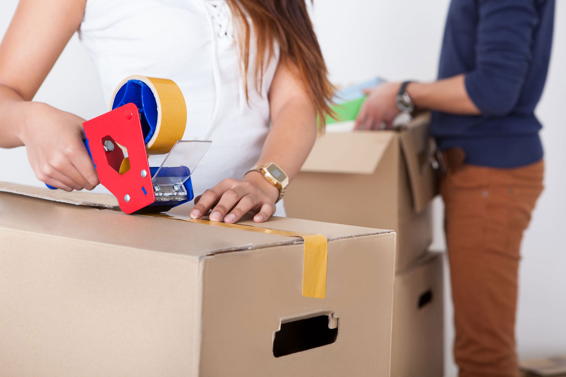 A woman is packing boxes in the room.